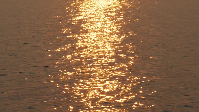 Golden water reflection Glistening during sunset, beautiful nature scene concept.