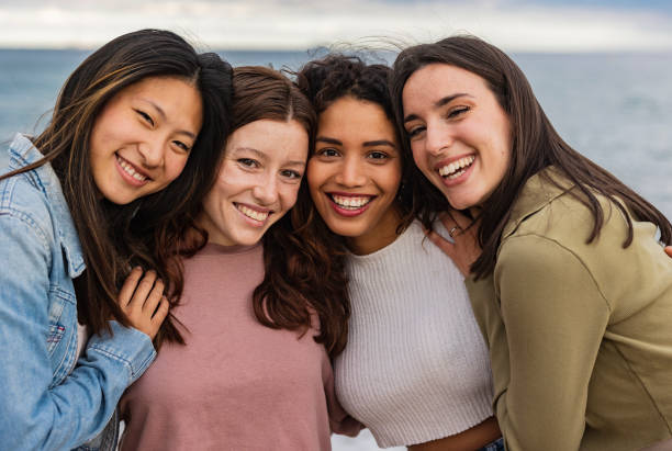 istock Diversity, multi-ethnic beauty concept. Four beautiful smiling ladies of different races, Hispanic, Asian and Caucasian, natural, posing on the sea background 1494230516