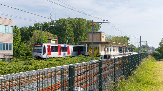 Vlaardingen, The Netherlands - May 28-2023  - Subway train leaving Vlaardingen Oost metro station, Hoekse Lijn