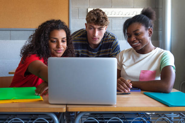 istock Multiracial group of high school students doing homework research together using laptop in class. 1494236413