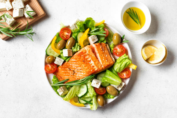 istock Grilled salmon fish fillet and greek salad 1494237635