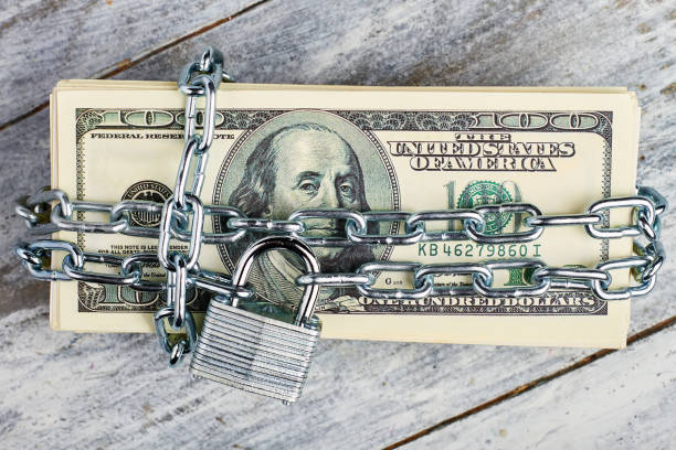 istock Locked dollars on wooden background. 1494239773