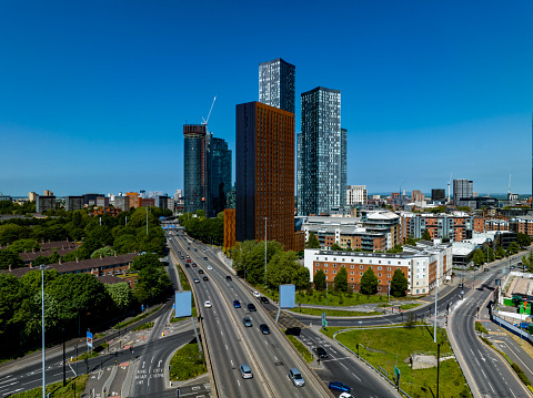 An aerial photograph of skyscrapers in Deansgate, Central Manchester, England. The photograph was produced on a bright sunny day with clear blue skies. The Mancunian Way (Short Motorway) can be seen running along the left hand side of the photograph.