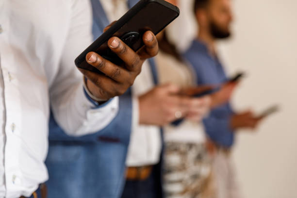 istock Group of unrecognizable people standing in line and using their smart phones 1494242342