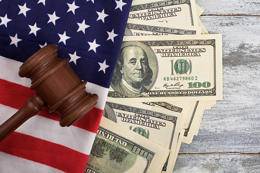 Gavel, dollars and American flag. National justice and democracy.