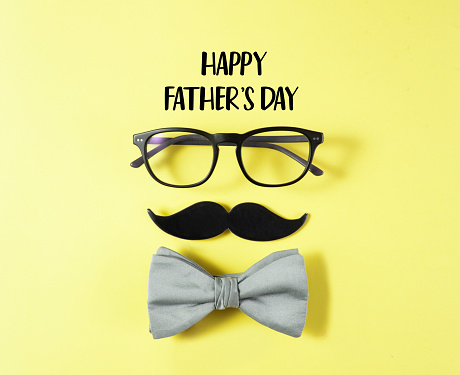 Happy Father's Day concept with eye glasses, bow tie and mustache paper  on yellow background