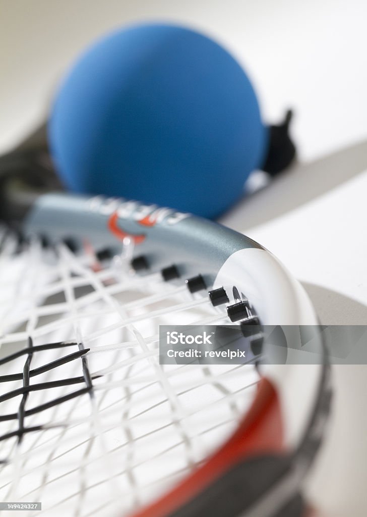 Raquetball Close Up Blue racquetball blurred near handle. Part of strings and racquet are in focus. View from head of racquet. Racketball Stock Photo