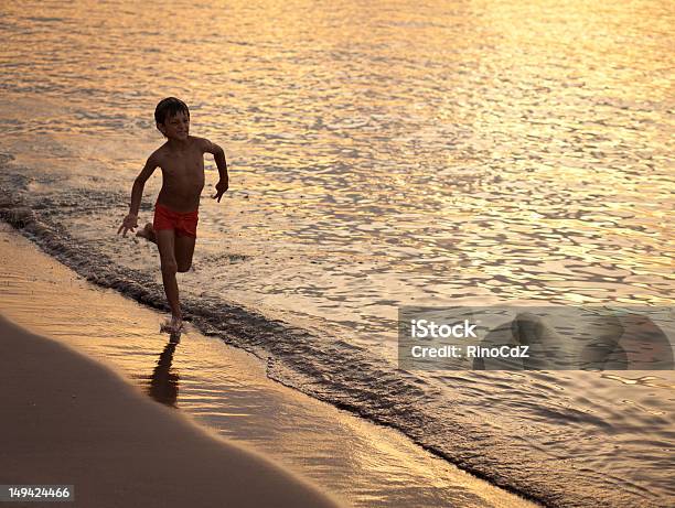 Running Chłopiec Na Seashore O Zachodzie Słońca - zdjęcia stockowe i więcej obrazów Biegać - Biegać, Chłopcy, Dziecko