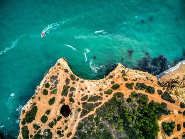 Breathtaking aerial view of the majestic Benagil cave and beach, with its turquoise waters and beautiful rock formations