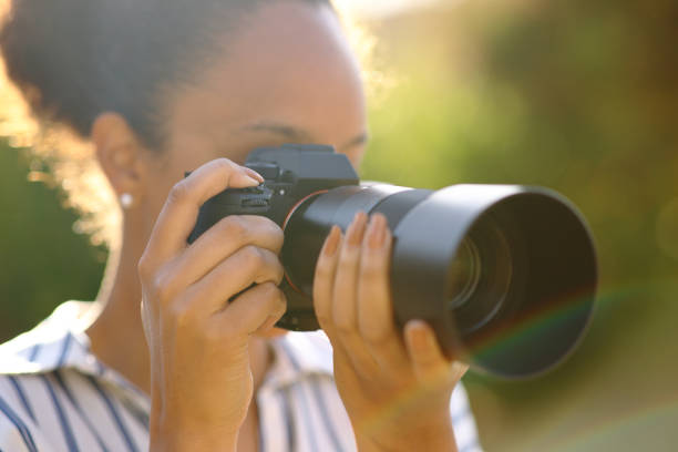 istock Black photographer taking pictures in a park 1494247412