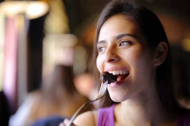 Happy woman eating meat in a restaurant