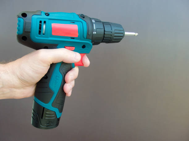 istock Hand 's man with screwdriver. The worker using an electric drill screwdriver, close-up. Concept of repair and construction services. 1494247645
