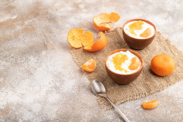 istock Grained cottage cheese with tangerine jam on brown concrete, side view, copy space. 1494247674