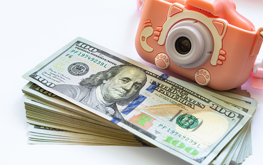 US 100 dollar banknotes and toy photo camera for design purpose