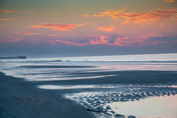 istock Scenic view of lingering tidal pools at Myrtle Beach, SC by the Apache Pier just before sunrise 1494250245