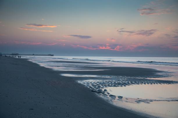 Scenic view of lingering tidal pools at Myrtle Beach, SC by the Apache Pier just before sunrise