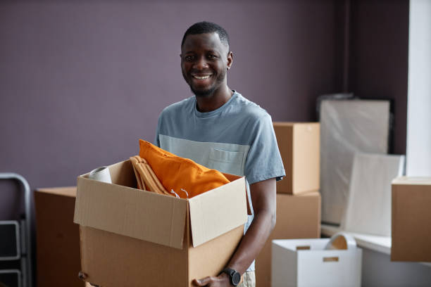 istock Man carrying boxes in new home 1494251871
