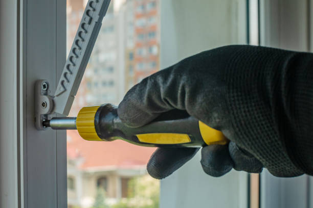 istock Male using screwdriver tightens screw that fixes plastic window opening limiter Close-up of gloved hand with screwdriver tightening window stopper fixing screw onto plastic window frame. Home repairs 1494257483
