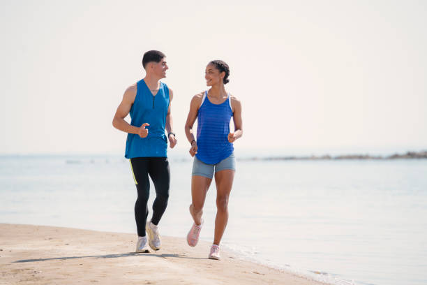 istock Young couple jogging together on the beach 1494257510