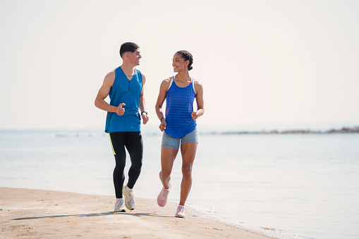 Young couple jogging together on the beach