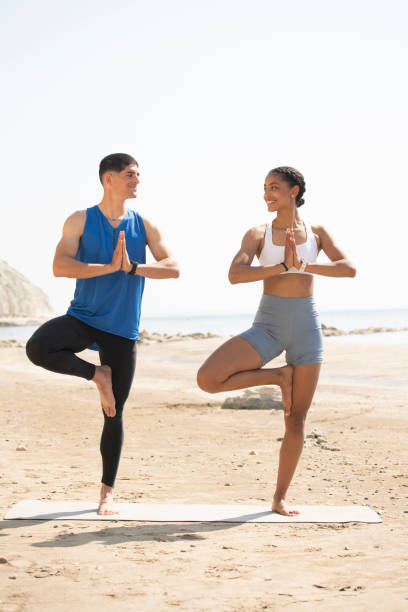 istock Young couple doing exercise together on the beach 1494257538