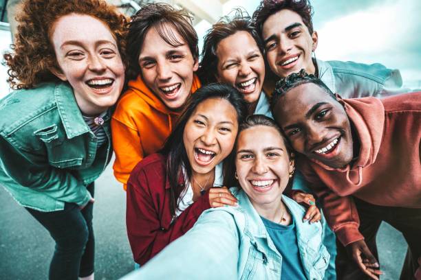 istock Multicultural best friends taking selfie pic with smart mobile phone outside - Laughing teenagers having fun on city street - Life style concept with guys and girls hanging out together 1494257542