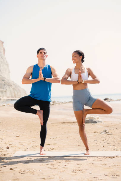 istock Young couple doing exercise together on the beach 1494257545