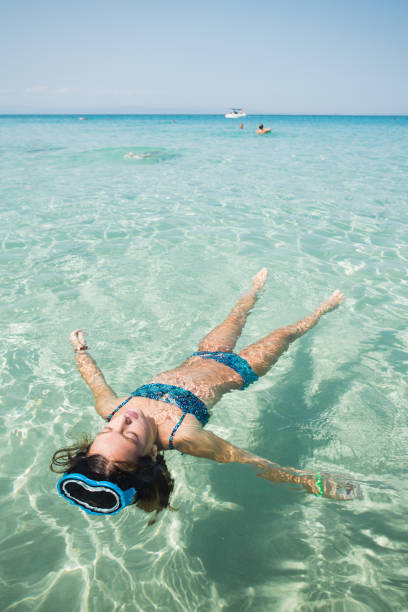 istock Young girl relaxing while floating on the water 1494258191