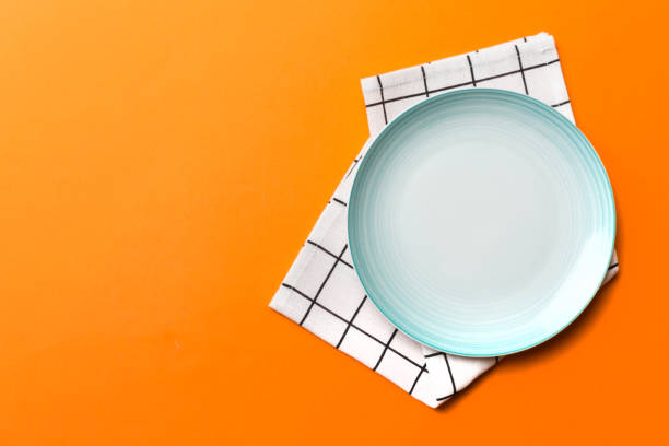 istock Top view on colored background empty round blue plate on tablecloth for food. Empty dish on napkin with space for your design 1494258216