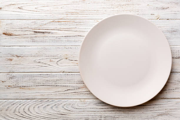istock Top view of empty light plate on wooden background. Empty space for your design 1494258816