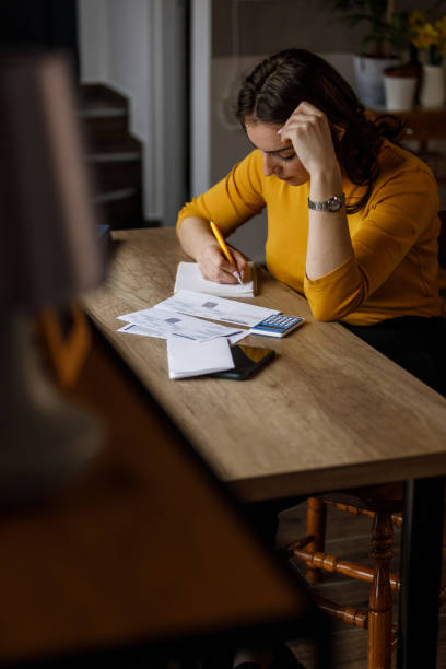 istock Young woman sorting out her monthly bills and struggling with finances 1494262414