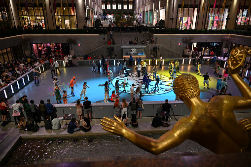 New York, USA, 13. April 2023 - Flipper's Roller Boogie Palace event at the rink of the Rockefeller Center plaza, with the golden Prometheus in Manhattan New York, USA in the background.