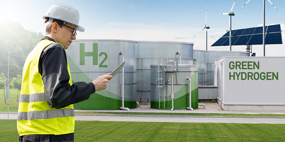 Engineer with tablet computer on a background of Hydrogen factory