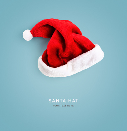 Christmas santa hat on blue background. Color card. Creative layout. Flat lay, top view. Holiday concept