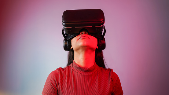 Young Asian Indian woman wearing virtual reality headset, a girl with VR glasses concept studio portrait