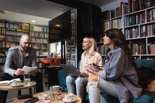 istock Group of three gen Z university students working together at laptop, writing notes, watching learning webinar, online lecture, reading tutorials on internet in college library. Education concept 1494268814