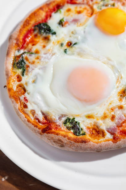 istock Pizza with fried egg, bacon, cheese and ketchup in a plate on a wooden table 1494270333