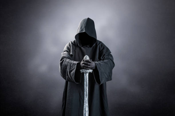 istock Warrior with hooded cape and medieval sword over dark misty background 1494271432