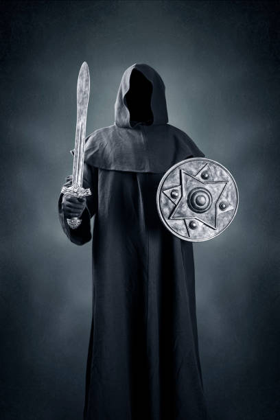 Dark knight with sword and shield over dark blue misty background
