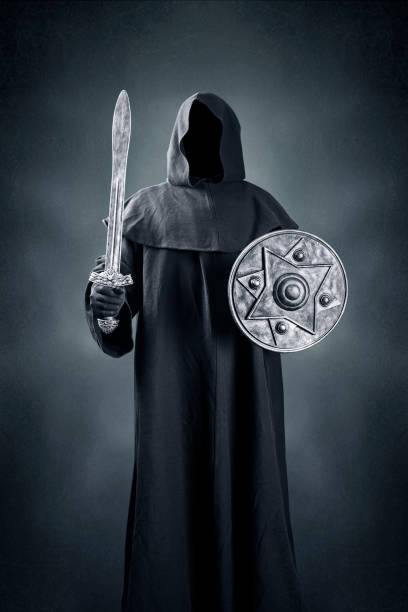 Dark knight with sword and shield over dark blue misty background stock photo