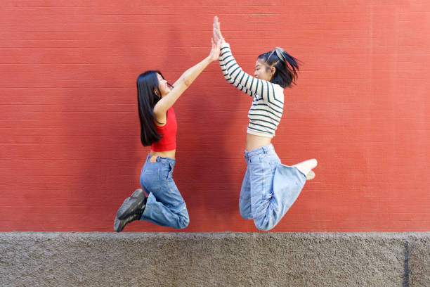 istock Joyful young Asian women giving high five while jumping 1494271641