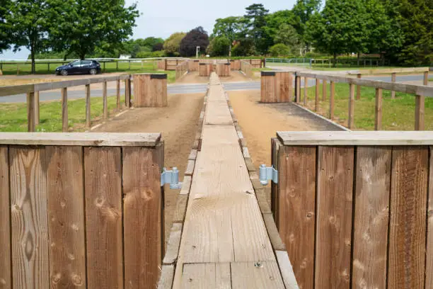 Race horse queuing barrier seen at the famous Newmarket, Suffolk, UK training ground. Horses line up to cross the distant body road.