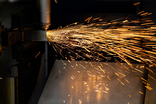 Electrical arc coming off metal as a tig welder works in a repair shop.