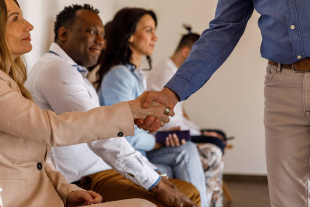 biznesmen ściskający dłoń kandydatom czekającym w kolejce na rozmowę kwalifikacyjną - unemployment waiting in line waiting room interview zdjęcia i obrazy z banku zdjęć