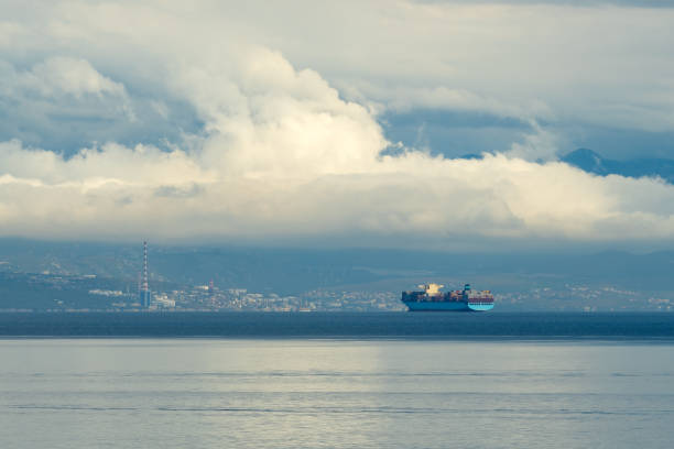 grande nave portacontainer che naviga in mare in mattinata nuvolosa vicino al litorale della città di rijeka in croazia - storm sea business uncertainty foto e immagini stock
