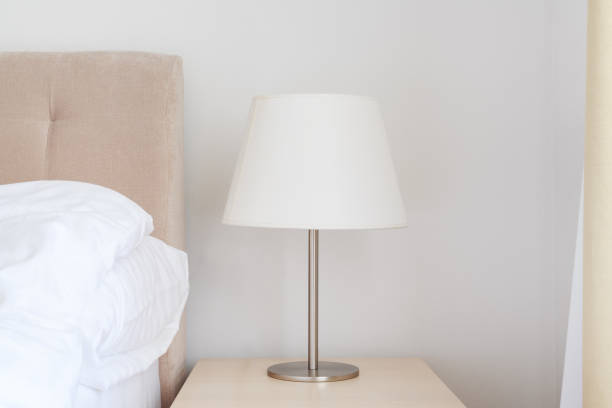 istock Elegant bedside lamp with white shade on night table in bedroom 1494273842