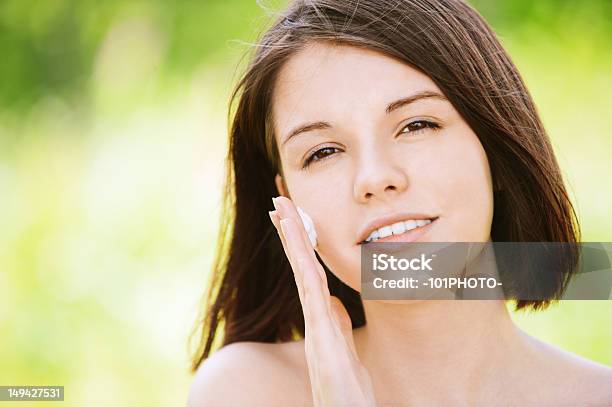 Retrato De Joven Atractiva Mujer Poner Crema En La Cara Foto de stock y más banco de imágenes de Adolescencia