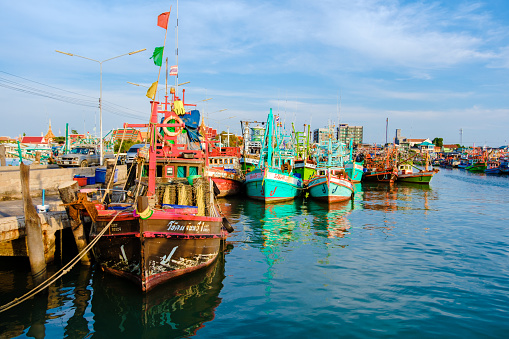 Bangsaray Pattaya Thailand May 2023, the fishing harbor at the fishing village Bangsaray during sunset with colorful wooden fishing boats