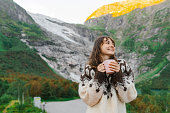 Woman drinking coffee on the background of the glacier