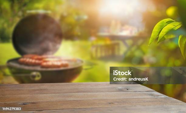 Summer Time In Backyard Garden With Grill Bbq Wooden Table Blurred Background Stock Photo - Download Image Now